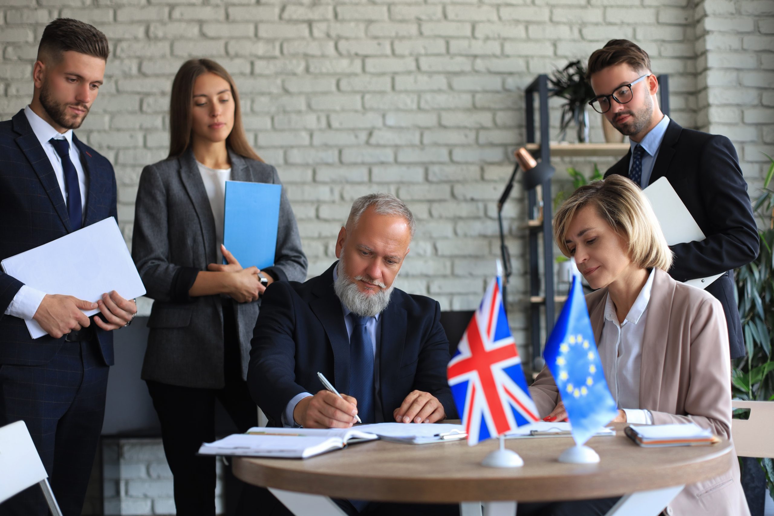 Two business partners signing a document. The European Union The United Kingdom